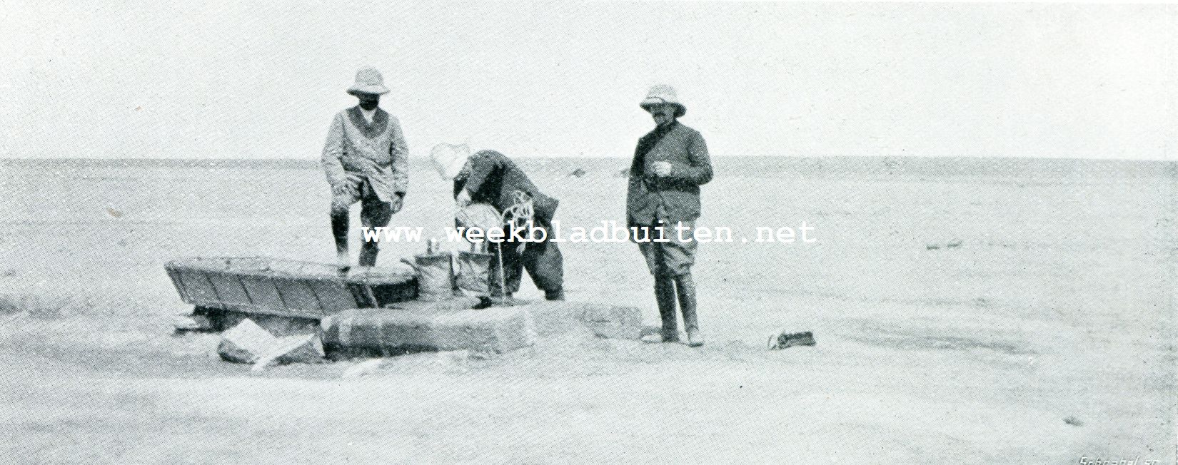 Peking-Parijs. In de Gobi-Woestijn. De deelnemers nemen uit een drinkput voor kameelen versch water in