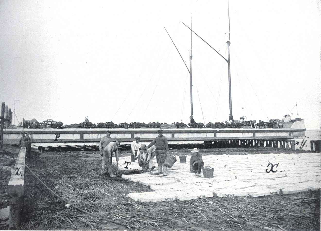 De betonwerken op het eiland Schouwen. Het monteeren van een betonzinkstuk, X: T is een blok dat juist aangebracht wordt, Y en Z zijn de houten jukken, P is de ponton waaronder een betonzinkstuk gereed ligt
