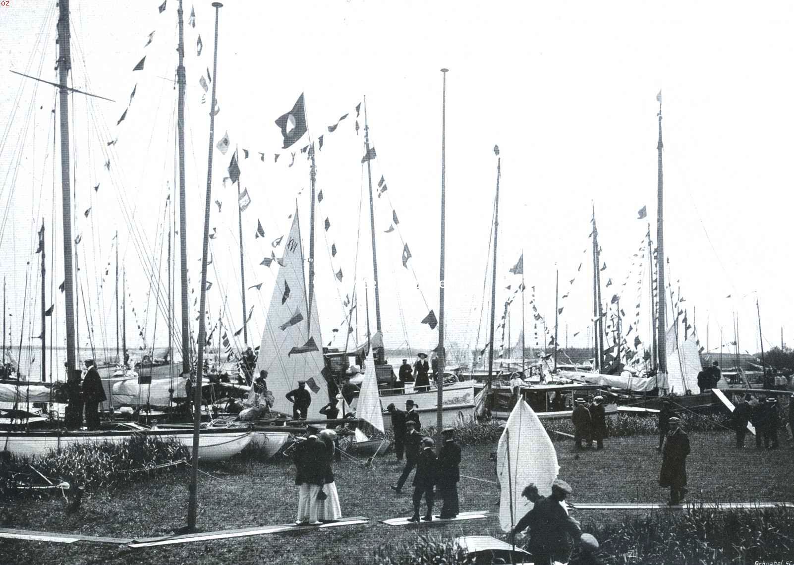 De zeilwedstrijd op het Braassemermeer. Jachten ter opluistering aanwezig, en deelnemers, hun beurt afwachtend, vastgemeerd aan het eiland