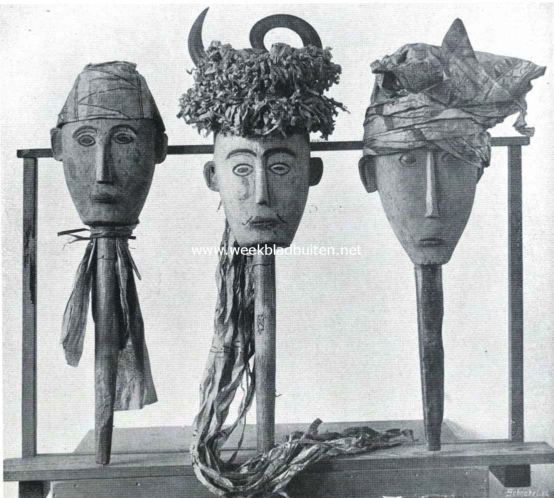 Drie doodenmaskers van Koekoe, Celebes. (Hoogte van het linkermasker, met handvat, 57 cM.)