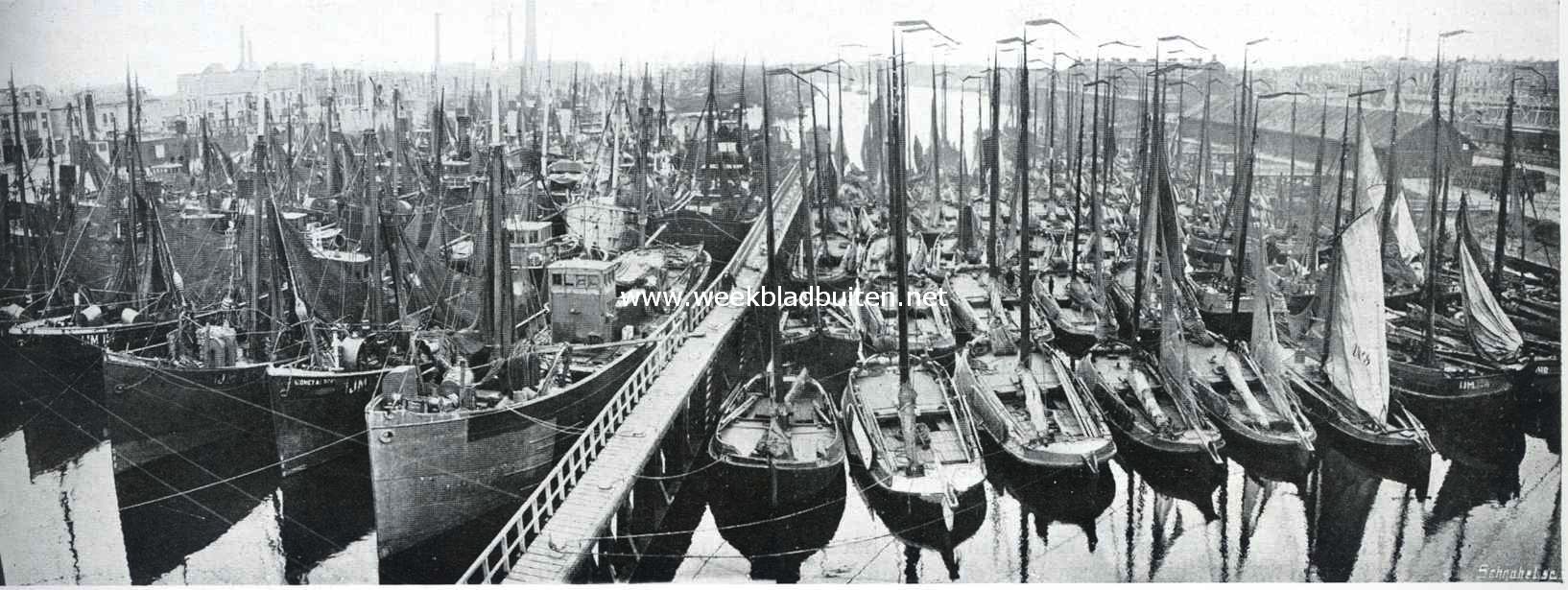 Gezicht van den watertoren te Ijmuiden tijdens de staking der visschers op de geheel met schepen gevulde visschershaven. Links van de loopplank de trawlers, rechts de botters