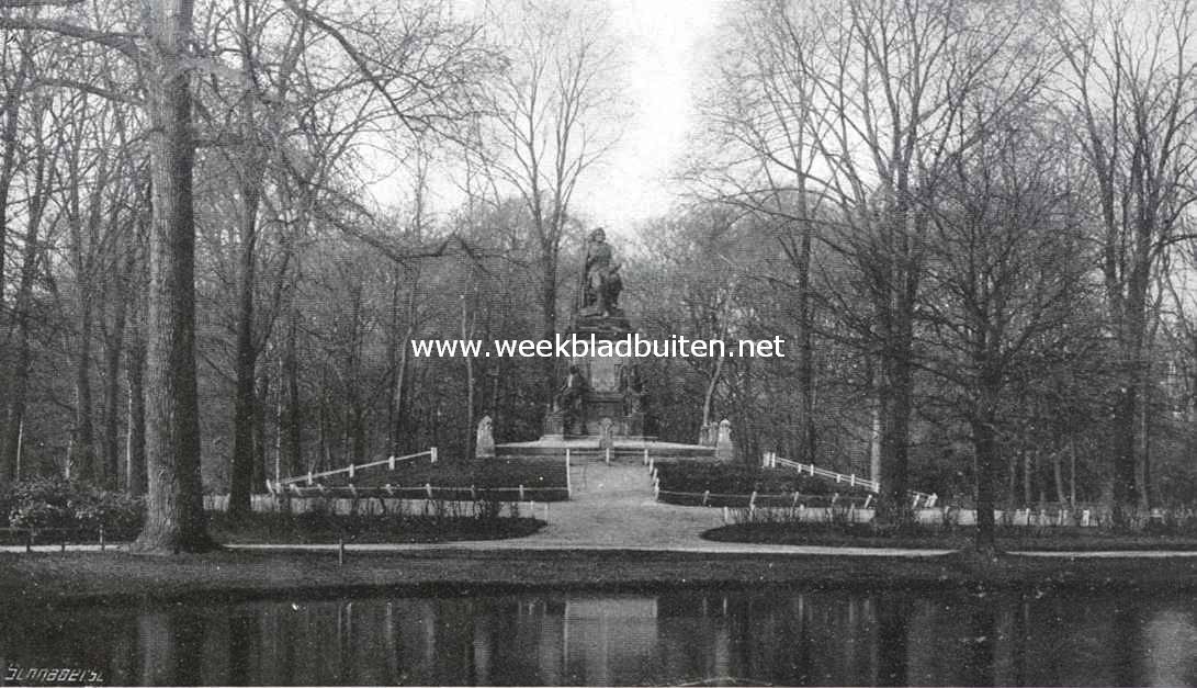 De halve eeuw van het Vondelpark. Vondel's gedenkbeeld in 1914, de boomen rondom zijn opgeschoten en het voetstuk van het beeld is aan vervuiling prijsgegeven