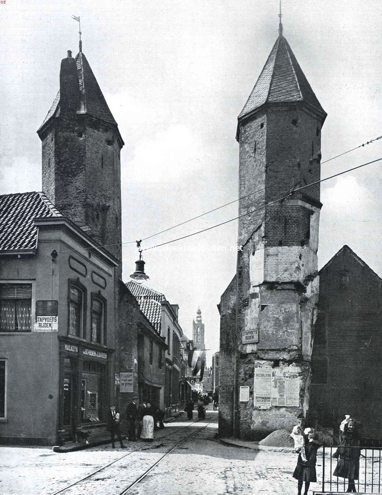 Kijkje in de Langestraat te Amersfoort. Op den voorgrond de torentjes der Kamperbinnenpoort, tot slooping waarvan weldra zou zijn overgegaan, als niet bij Kon. Besluit van 28 April L.L. het desbetreffende besluit van Amersfoort's gemeenteraad was vernietigd wegens strijd met het algemeen belang. In 't verschiet de O.L. Vrouwetoren