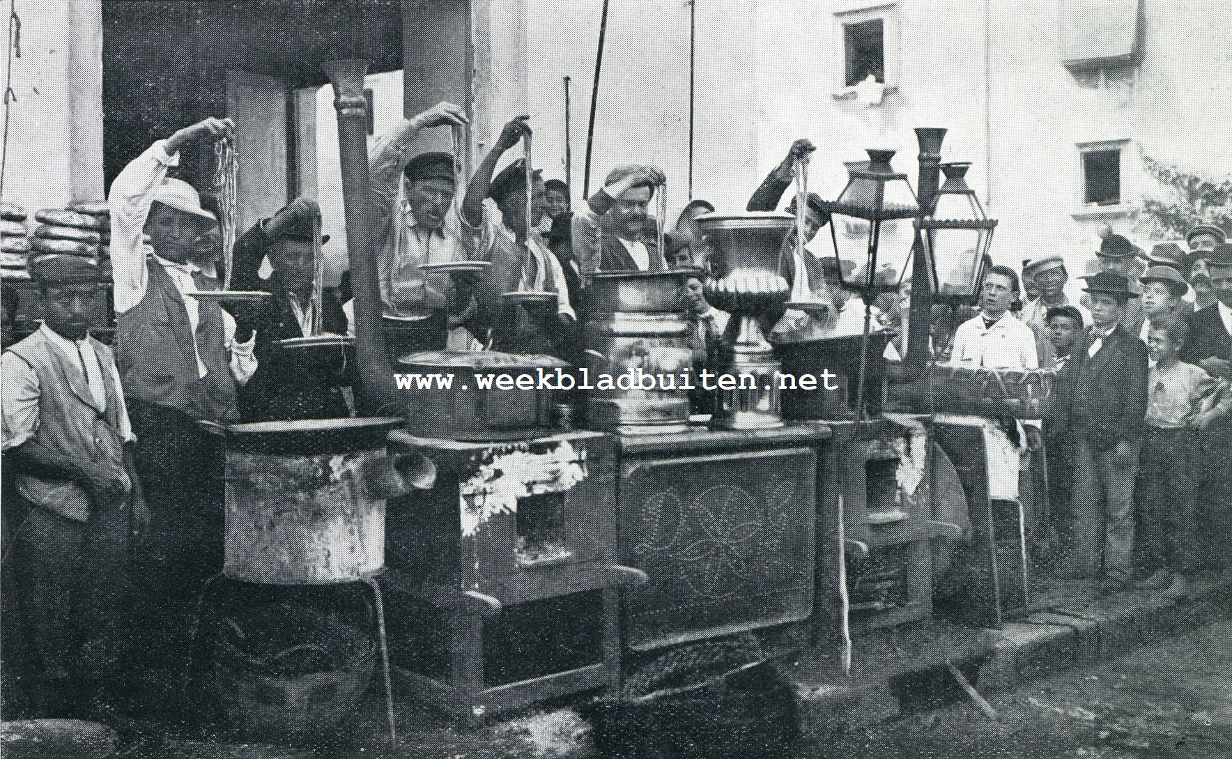 MACARONIVERKOOPER TE NAPELS. EENIGE JAREN GELEDEN IN DE VOLKSWIJKEN NOG EEN ALLEDAAGSCH TOONEELTJE. THANS ZIET MEN, ZELFS TE NAPELS, ZELDEN MEER, DAT MACCARONI MET DE VINGERS WORDT GEGETEN