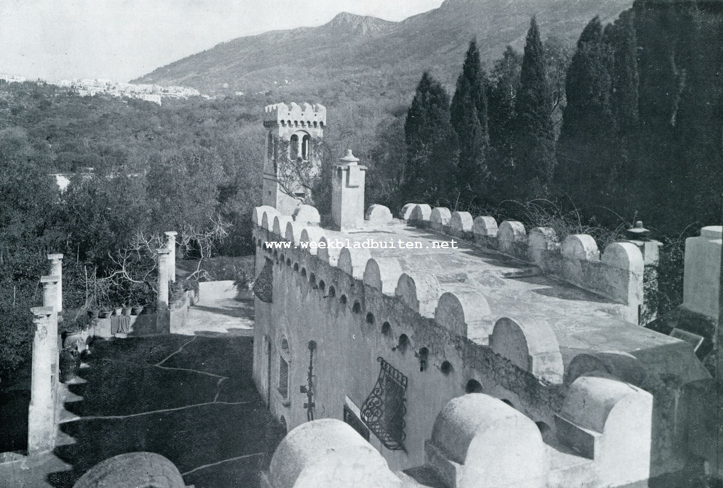 UITZICHT VAN EEN SLAAPKAMER IN DEN TOREN VAN DE VILLA TORRE Dl MATERITA OVER DE GEKANTEELDE MUREN, HOF EN PARK, MET IN DE VERTE HET LACHENDE DORPJE ANACAPRI. RECHTS DE MONTE SOLARO