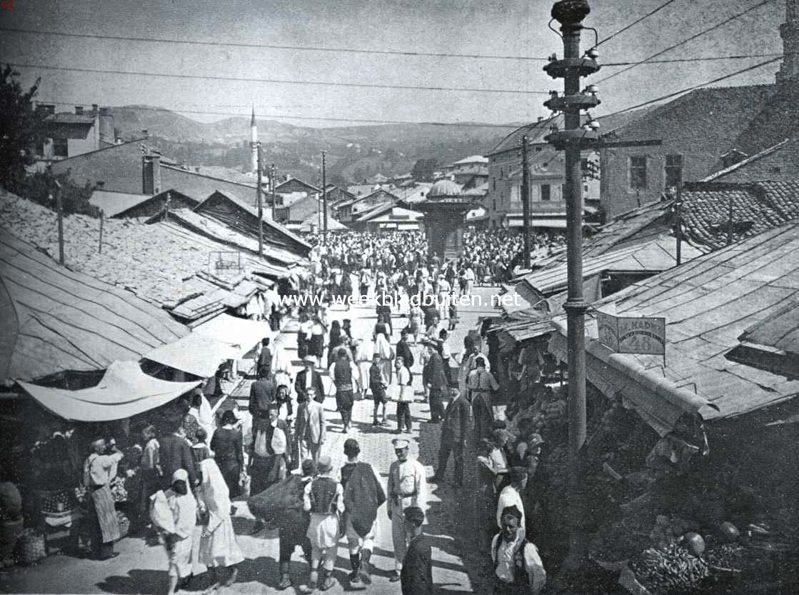 In de hoofdstad van Bosni. Marktdag te Sarajevo, op den achtergrond, bij den kiosk, begint de Carija, de Turksche bazaarwijk