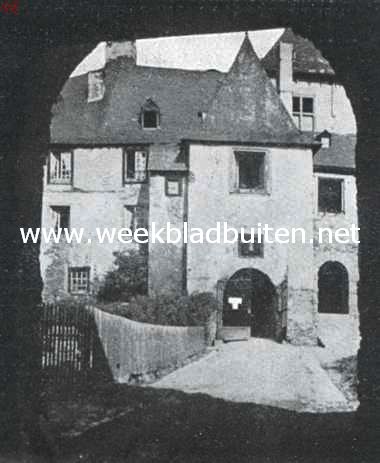 Een lage poort, die de zonnige voorzijde in een donkere omlijsting gevat houdt