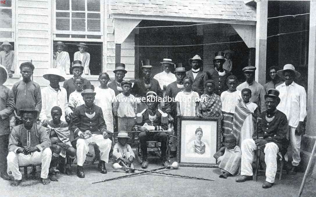 Een Afrikaansche samenleving in het binnenland van Suriname. Amakti te Paramaribo, omringd door eenige zijner kapiteins, andere Bosch- en enkele stadsnegers