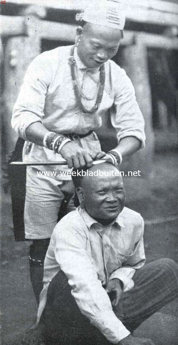 Het toilet der Apo-Kajans van Centraal Borneo. De scheerbaas aan den arbeid bij de Apo-Kajans. Duidelijk zichtbaar zijn de polsringen, van plantenvezels, versierd met kralen, en de halssnoeren van kralen. Bij deze laatste bevinden zich kralen, die eeuwen oud zijn en die magische kracht zouden bezitten