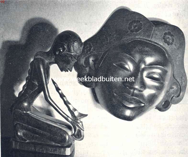 Moderne Balineesche houtsnijkunst. Modern Balineesch houtsnijwerk, links: een krisdanser (ebbenhout); rechts een masker met in den haartooi de heilige kamodja-bloem, waarmede alle Balirs zich tooien